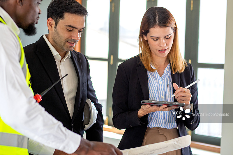 工程师团队会议，讨论和规划与室内设计师的设计，涉及施工现场的项目，建筑师团队的发展和蓝图的审查，工业和工人。图片素材