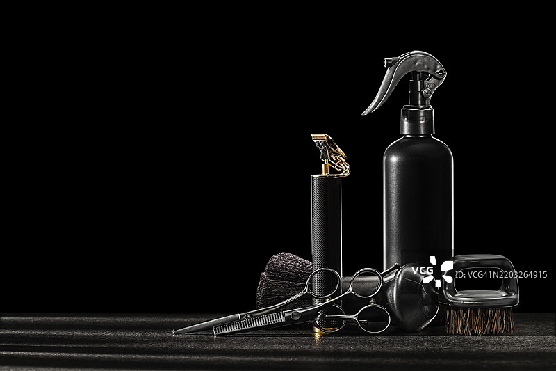 黑色理发工具。颈部胡须刷，专业理发器，修剪胡须，无线理发剃须机，喷水器。黑色背景。图片素材