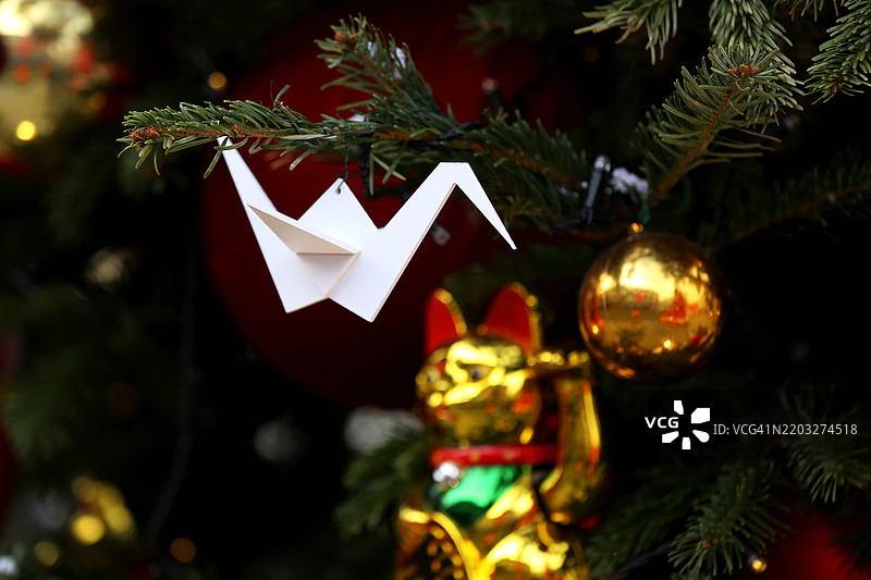 户外春节。招财猫与纸鹤和节日装饰的圣诞树图片素材