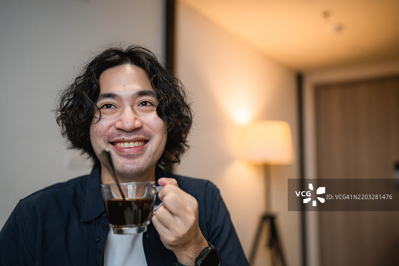 帅气的男人在早晨往杯子里倒咖啡图片素材