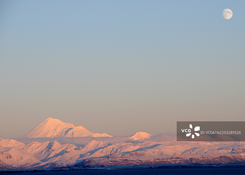 阿拉斯加伊泽姆贝克国家野生动物保护区，冷湾背后的夕阳下，月亮与达顿山。图片素材