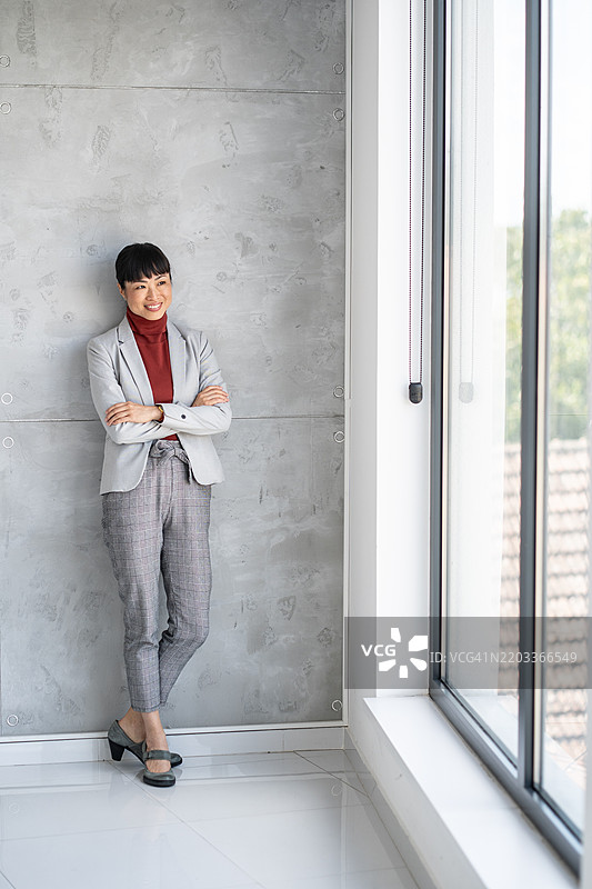 微笑的职业女性双臂交叉站立图片素材