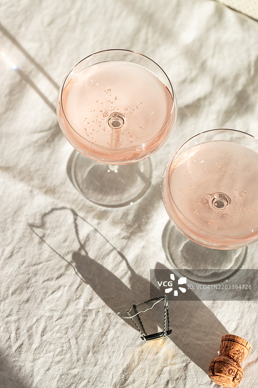 桌子上摆放着两杯玫瑰色普罗塞克的静物画。图片素材