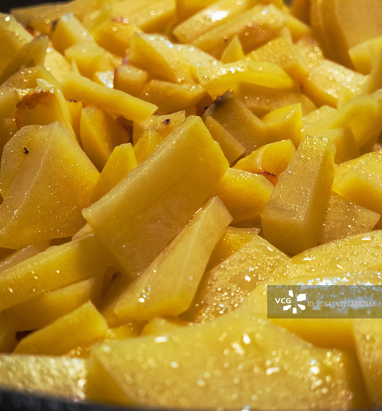 新鲜切好的金色土豆块，准备在色彩斑斓的厨房台面上进行美味的烹饪创作图片素材