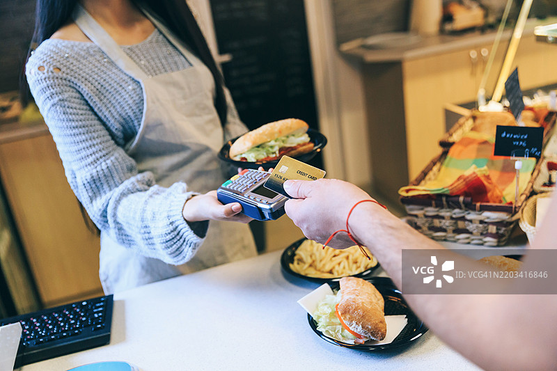 男子在快餐店用信用卡支付午餐图片素材