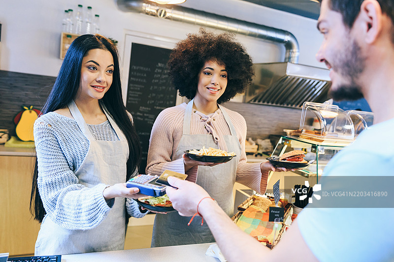 男子在快餐店用信用卡支付午餐图片素材