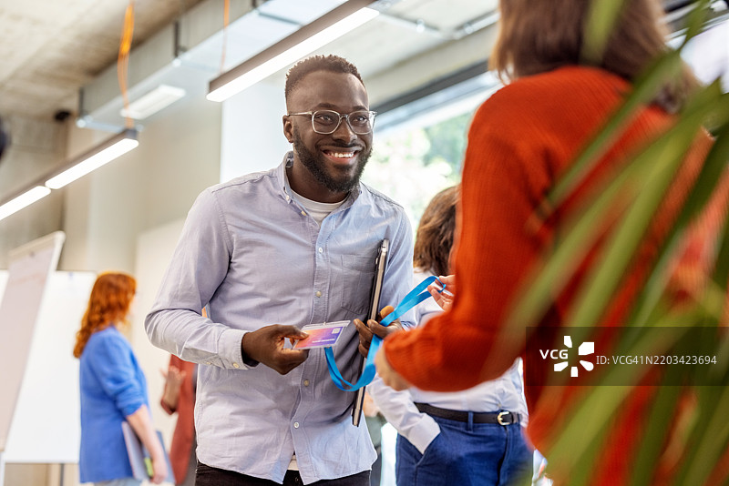 快乐的商人在研讨会上到达并领取身份证件图片素材