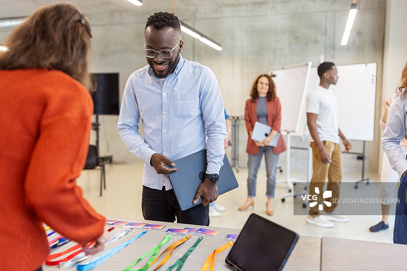 商人在会议注册期间领取身份徽章图片素材