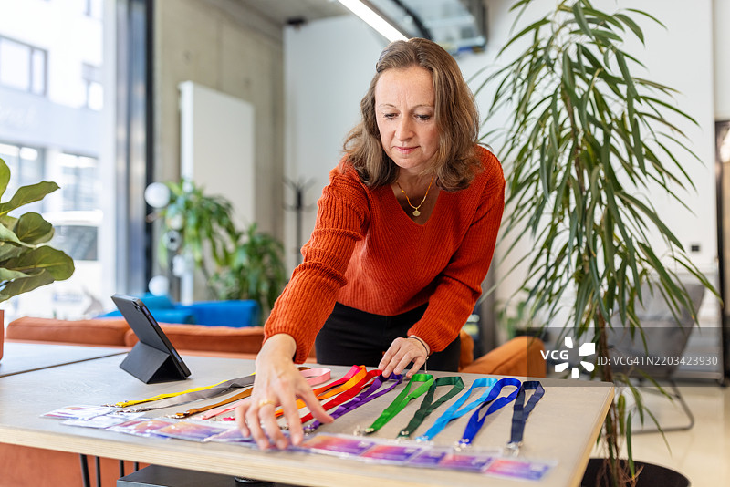 女商人在接待处为与会者整理身份证件图片素材