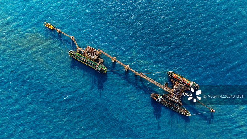 油轮停靠在装卸码头，准备从炼油厂装卸石油的鸟瞰图。图片素材