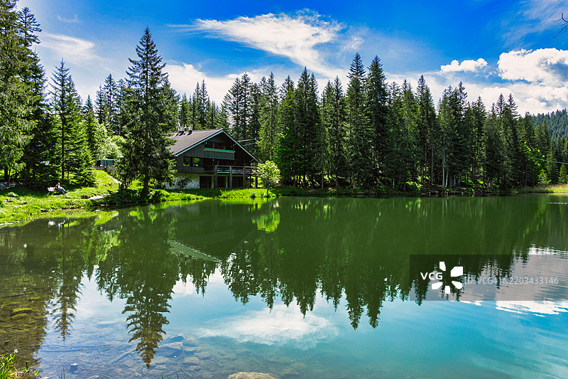 在意大利威尼托地区的科梅利科超级镇，圣安娜湖白天拍摄的照片，照片中还可以看到一个典型的建筑，融入自然之中。图片素材
