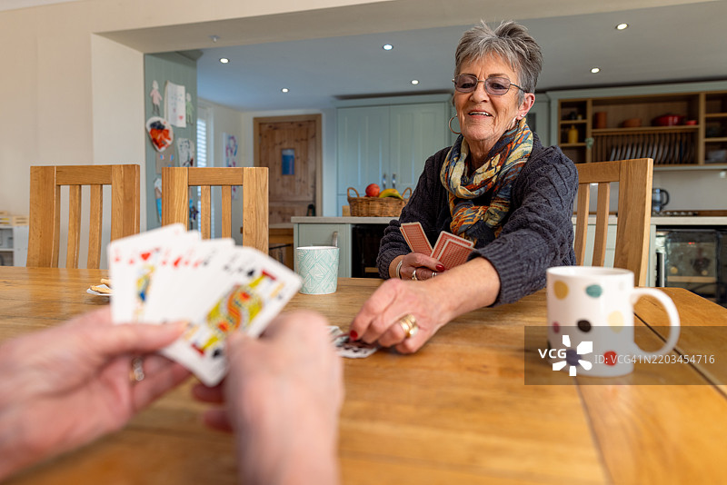 朋友们在家享受纸牌游戏图片素材