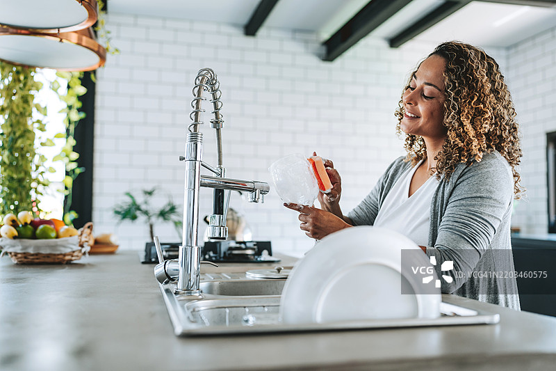 女人用海绵清洗酒杯图片素材