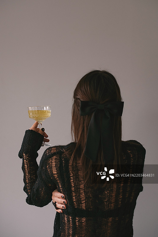 从背后看喝着葡萄酒的女孩图片素材