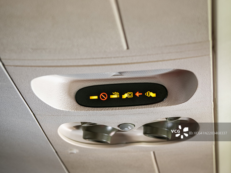 商用飞机内部点亮的安全灯信号。图片素材