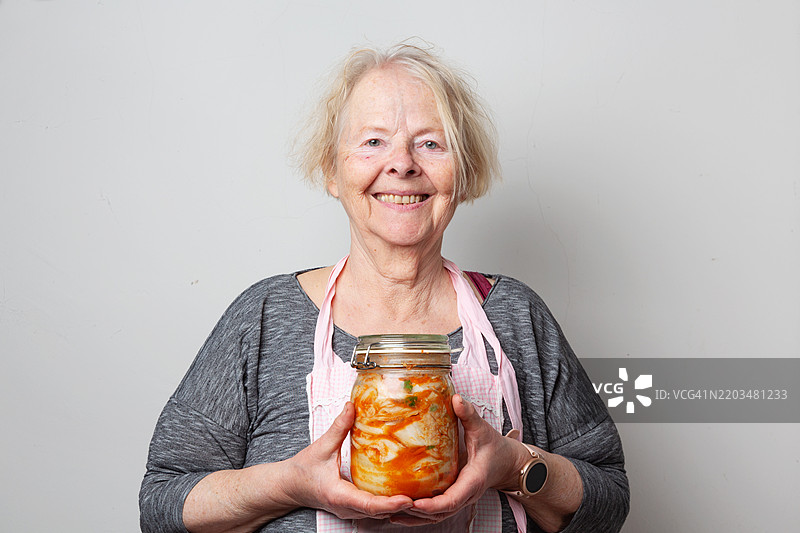 发酵食品：一位老年女性手持泡菜罐图片素材