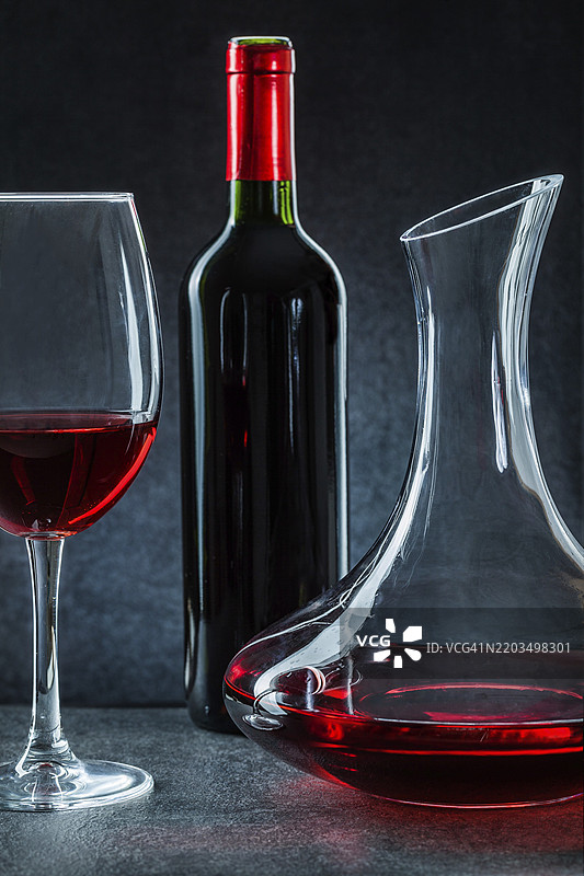 黑色背景上的红酒酒瓶和酒杯与醒酒器图片素材
