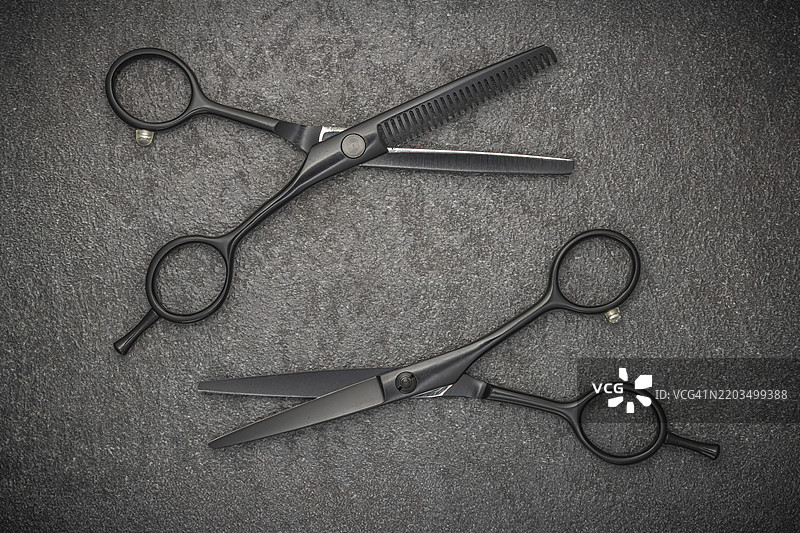 理发师专业工具。发型时尚。一把专业理发剪刀放在黑色背景上。图片素材