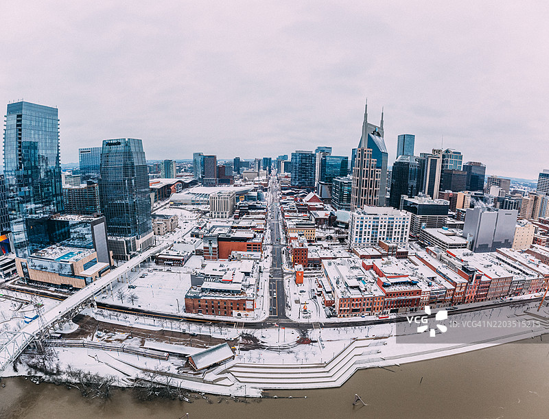 田纳西州纳什维尔市中心的百老汇超广角全景，雪天冬晨从库姆伯兰河靠近尼桑体育场拍摄的旅游中心景观图片素材