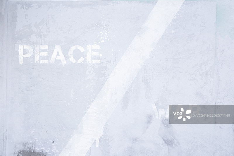 和平与战争的对立概念，画在一面风化的浅灰色墙上。图片素材