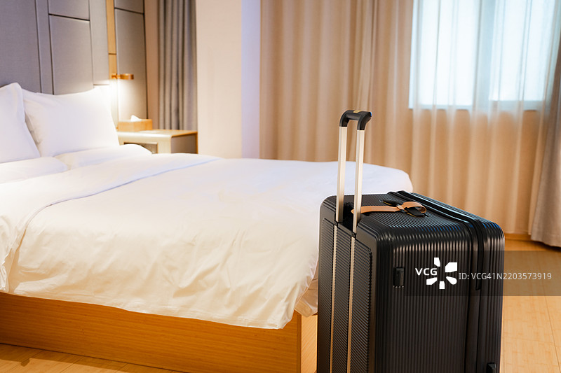 一款现代行李箱放在华丽的现代酒店房间里图片素材