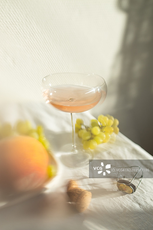 虚化的玫瑰普罗塞克酒杯和水果。图片素材