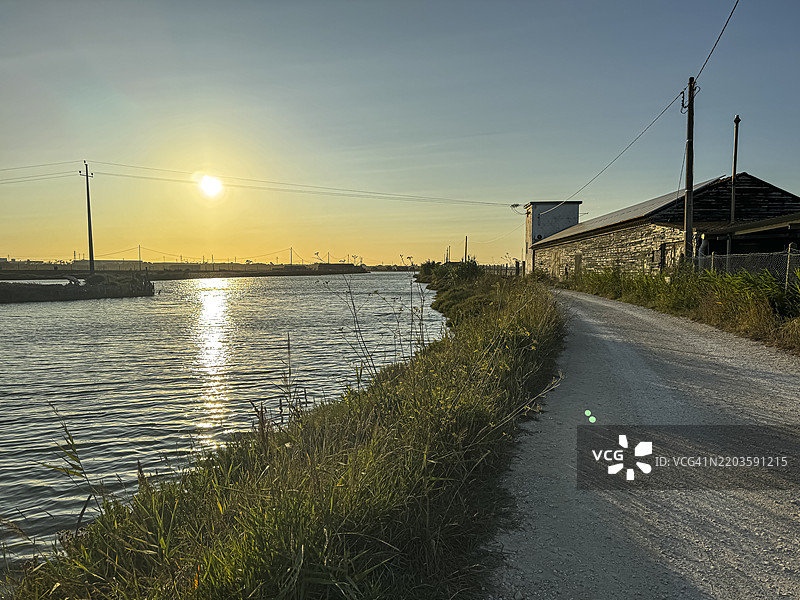 葡萄牙菲盖拉达福日落时分的盐仓和海盐平原旁的河口。图片素材
