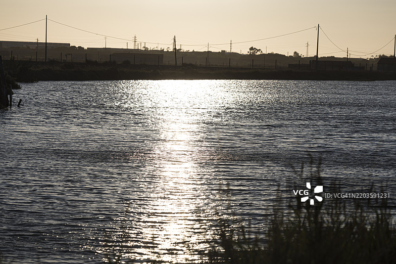葡萄牙菲盖拉达福斯的盐仓和海盐平原旁的河口，日落时分。图片素材