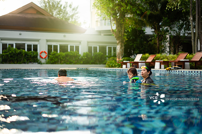 孩子和他的祖母在游泳池度假村里图片素材