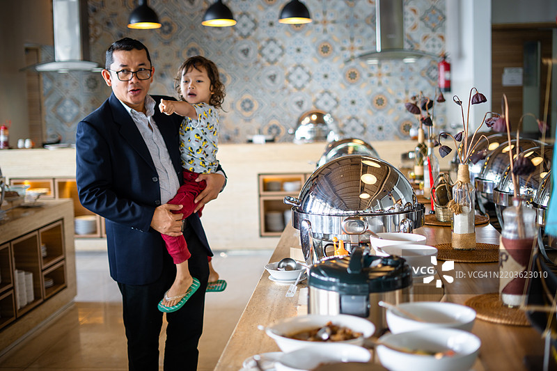 温馨的单身父亲和他的小儿子在酒店自助早餐时光图片素材