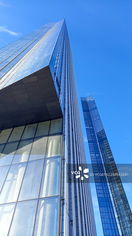 从低角度拍摄的高层摩天大楼城市办公楼，背景是蓝天图片素材