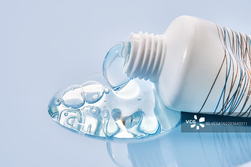 蓝色背景上小管子里倒出的洗发水纹理图片素材