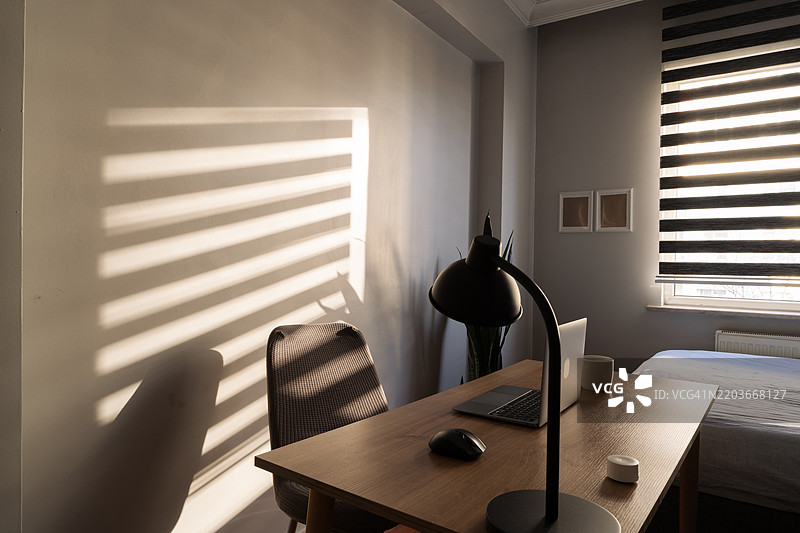 阳光透过百叶窗洒入温馨的家庭办公室图片素材