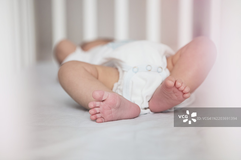 婴儿在摇篮中安静地休息，柔和的灯光和宁静的氛围。图片素材