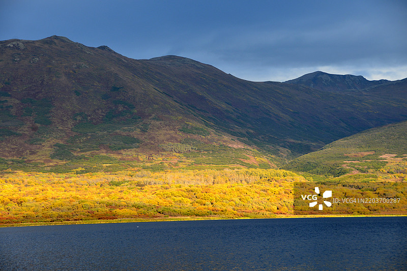 阿拉斯加科迪亚克国家野生动物保护区卡尔鲁克湖上，秋色的山脉沐浴在阳光下。图片素材