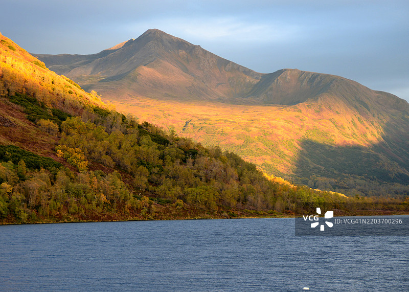 阿拉斯加科迪亚克国家野生动物保护区卡尔鲁克湖上，秋色的山脉沐浴在阳光下。图片素材