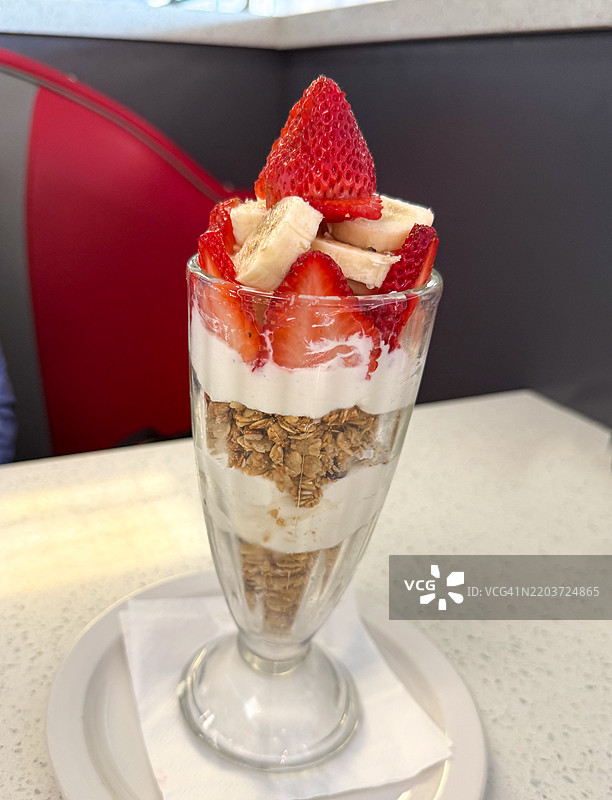 装满格兰诺拉麦片、酸奶和水果的玻璃杯图片素材