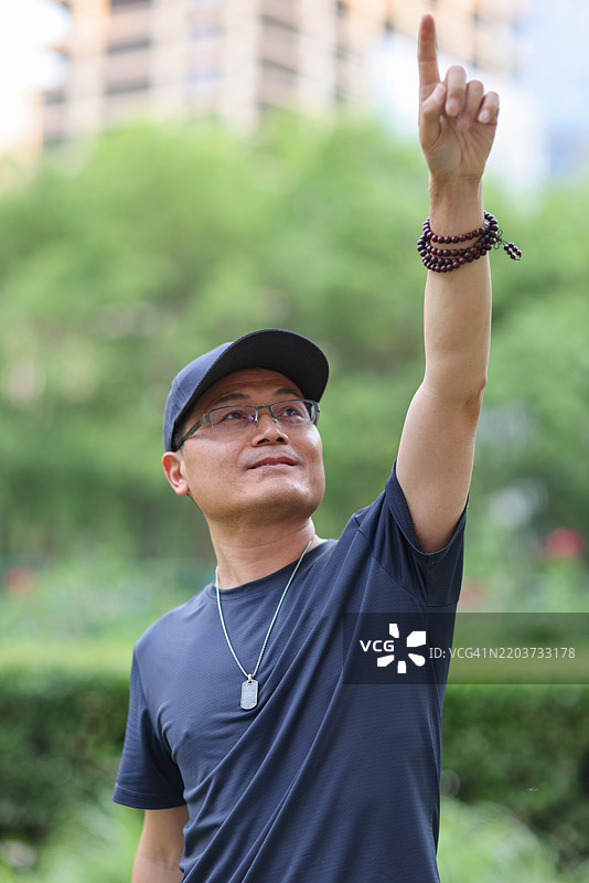 亚洲男子在户外指向天空图片素材