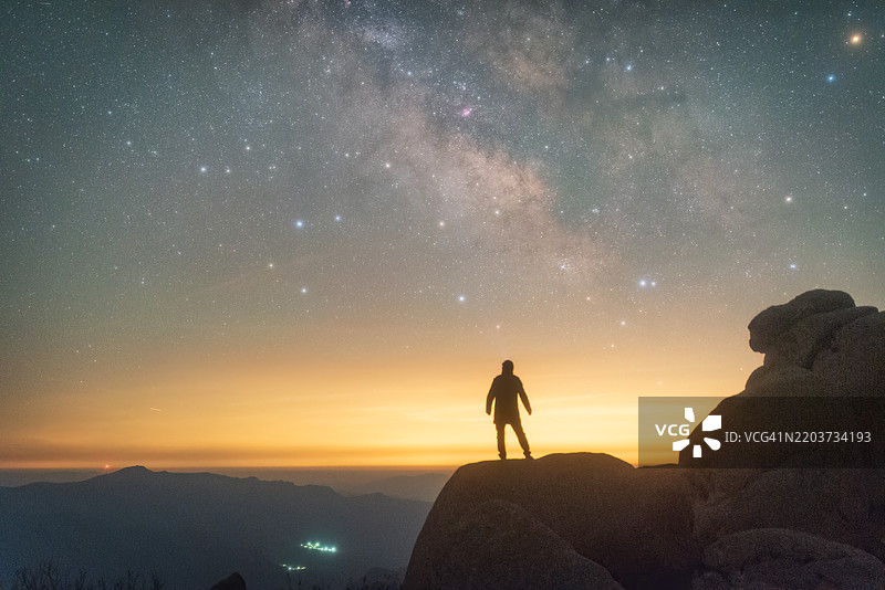 一个站在山顶上欣赏浩瀚银河的男人图片素材