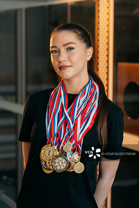 年轻运动员在比赛后自豪地展示她的奖牌图片素材