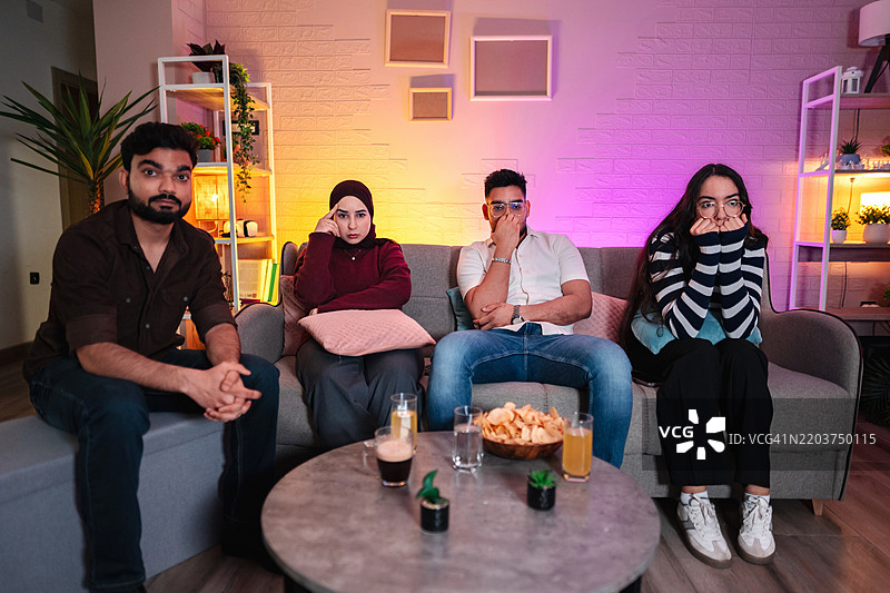 朋友们在家看恐怖电影，感到害怕图片素材