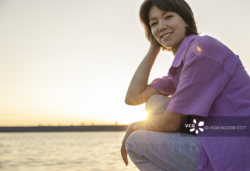 微笑的短发女性在海滩上享受闲暇时光图片素材