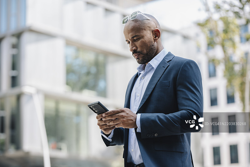 商人在建筑物前使用手机图片素材