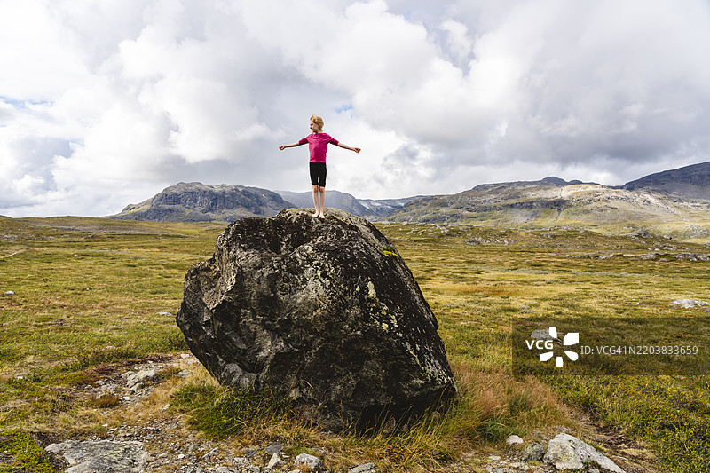 女孩站在库恩斯莱登徒步旅行道上的大石头上图片素材