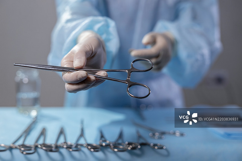 护士在手术台上握着手术夹。图片素材
