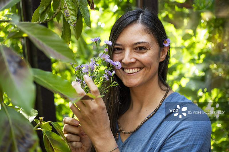 在凉亭中与花朵相伴的快乐女性图片素材