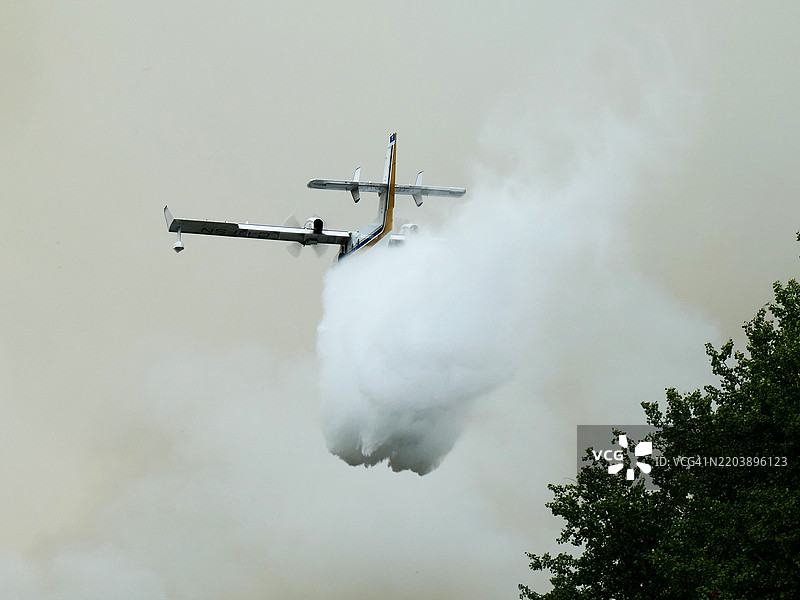 一架灭火飞机正在阿拉斯加基奈国家野生动物保护区向火灾投放水。图片素材