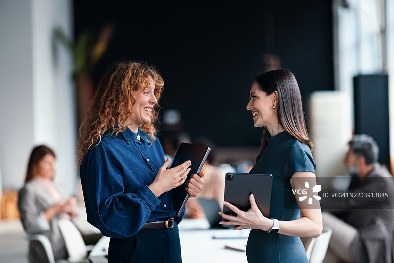 两位职业女性在现代办公室环境中讨论工作图片素材