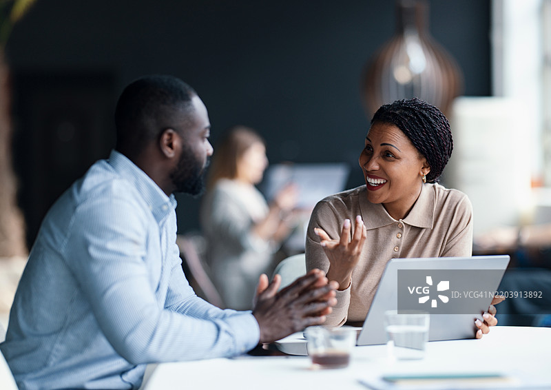 在商务环境中使用笔记本电脑进行专业讨论与协作图片素材