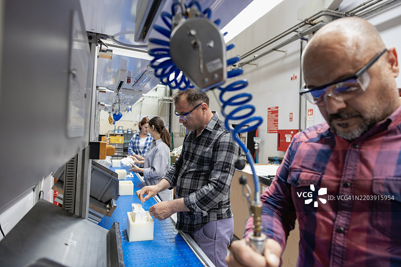 工厂生产线上的一组工人正在工作图片素材